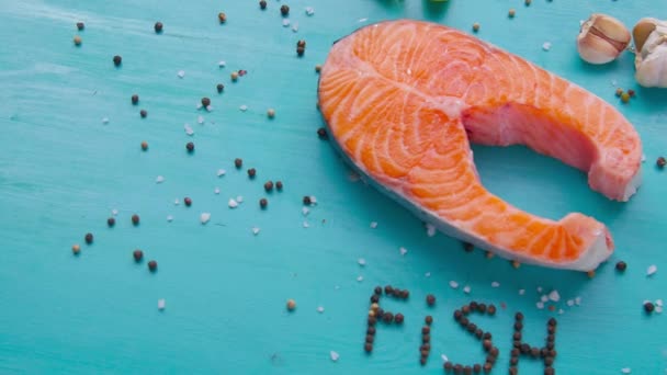 Filete de salmón crudo con especias sobre fondo azul — Vídeo de stock