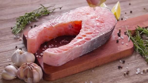 Bifteck de saumon cru et frais sur une planche d'ardoise et des épices autour. Concept d'alimentation saine — Video