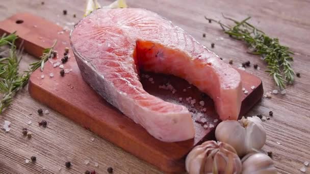 Сырой, свежий стейк из лосося на доске и специи. Концепция здорового питания — стоковое видео