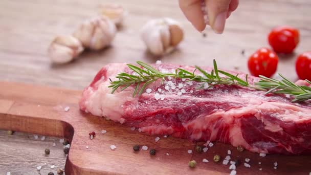 Nyers friss hús marhahús fűszerekkel és fűszerekkel rusztikus alapon — Stock videók