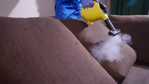 Furniture and apartment cleaning concept. Man cleaning couch with steam cleaner at home — 비디오