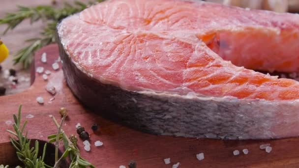 Syrový, čerstvý lososí steak na břidlicové desce a koření. Koncept zdravé stravy — Stock video