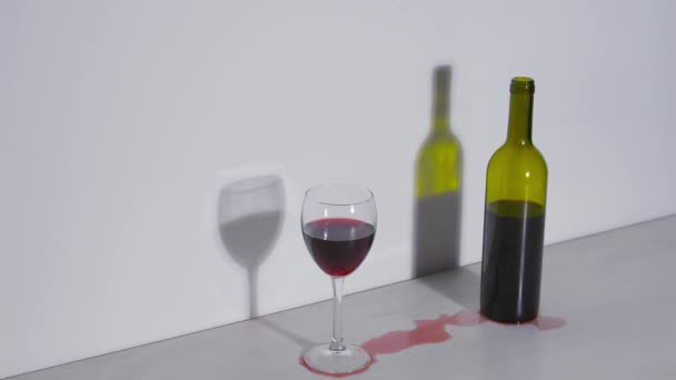 Tiro conceitual, uma garrafa de vinho e um copo em um fundo branco — Vídeo de Stock