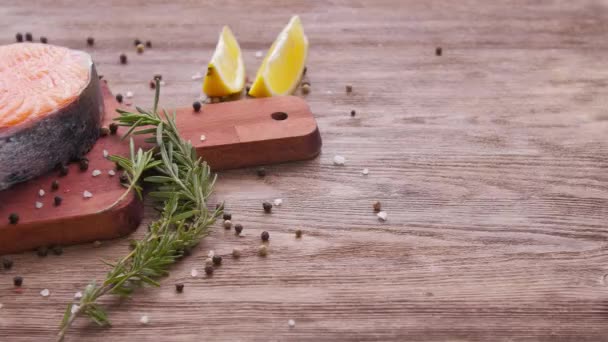 Meeresfrüchte und Kochkonzept. frisches rohes Lachssteak mit Gewürzen — Stockvideo