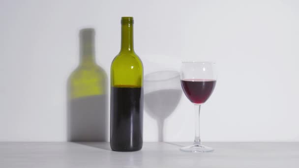 Konzeptionelle Aufnahme, eine Flasche Wein und ein Glas auf weißem Hintergrund — Stockvideo