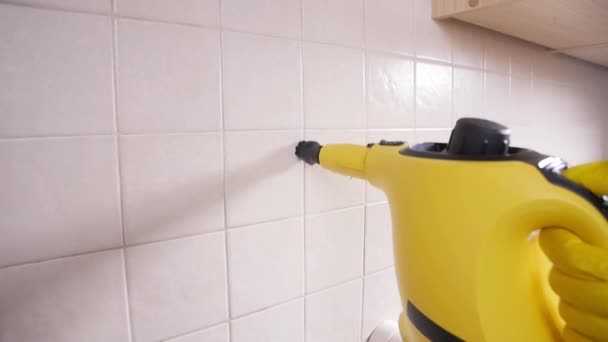 Концепція прибирання будинку. Чоловік прибирає кухню з пароочищувачем — стокове відео