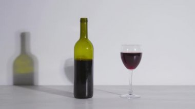 Conceptual shot, a bottle of wine and a glass on a white background