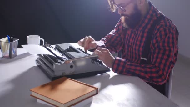 Conceito do dia dos escritores. Jovem escritor masculino em um quarto escuro digitando em uma máquina de escrever — Vídeo de Stock