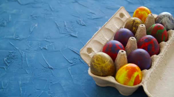 Huevos de Pascua de colores sobre fondo azul. Concepto de decoración de vacaciones de Pascua — Vídeo de stock