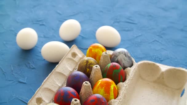 Színes húsvéti tojás kék háttérrel. Húsvéti ünnepi dekoráció koncepció — Stock videók