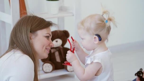 Concepto de discapacidad auditiva y su tratamiento. Linda niña con un audífono — Vídeo de stock