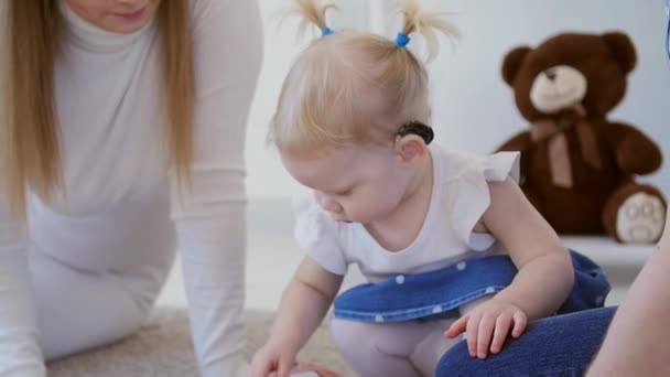 Concept de déficience auditive et leur traitement. Petite fille mignonne avec une aide auditive — Video