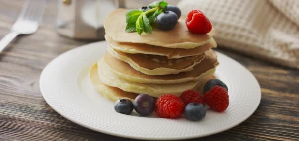 Mat och matlagning koncept. Stack pannkakor med färska bär, rotera skott — Stockvideo