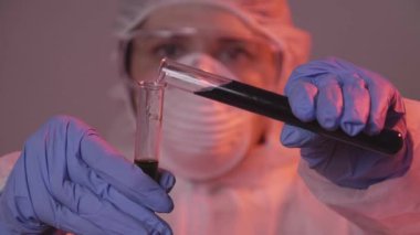 Koruma altındaki bilim adamı laboratuvara sıvı döküyor. Araştırma ve bilim konsepti