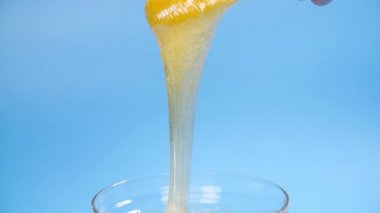 Güzellik ve vücut bakımı kavramı. Mavi arkaplandaki tüy dökümü için sıvı sarı şeker yapıştırıcısı veya ağda