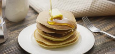 Yemek ve Yemek Konsepti. Tereyağlı krep yığını ve yavaş çekimde akçaağaç pekmezi.