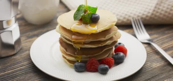 Konsep Makanan dan Memasak. Tumpukan pancake dengan berry dan sirup maple hangat dalam gerakan lambat — Stok Video