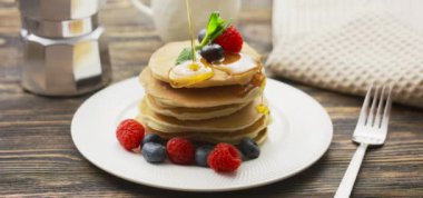 Yemek ve Yemek Konsepti. Yavaş çekimde böğürtlen ve akçaağaç pekmezli krep yığını.