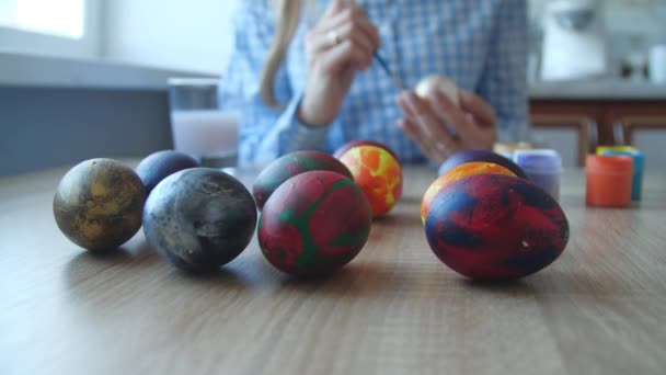 Jovem mulher gosta de pintar em ovos de fantasia para o festival de ovos de Páscoa. O símbolo do conceito de festival do ovo de Páscoa — Vídeo de Stock