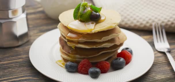 Eten en koken Concept. Stapel pannenkoeken met bessen en warme ahornsiroop in slow motion — Stockvideo