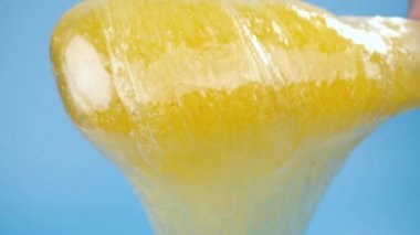 Güzellik ve vücut bakımı kavramı. Mavi arkaplandaki tüy dökümü için sıvı sarı şeker yapıştırıcısı veya ağda