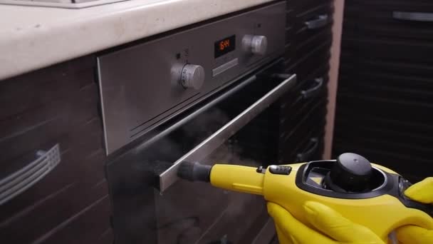 Concetto di pulizia casa. Uomo pulizia cucina con pulitore a vapore — Video Stock