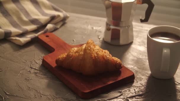 Concepto de comida y bebida. El desayuno de la mañana - el café y el croissant a la mesa — Vídeos de Stock