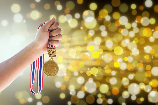 Κρατώντας ένα χρυσό μετάλλιο ενάντια, νίκη έννοια άνθρωπος. — Φωτογραφία Αρχείου