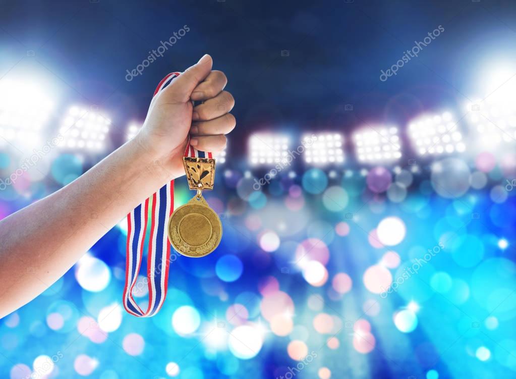 Man holding up a gold medal against,win concept.