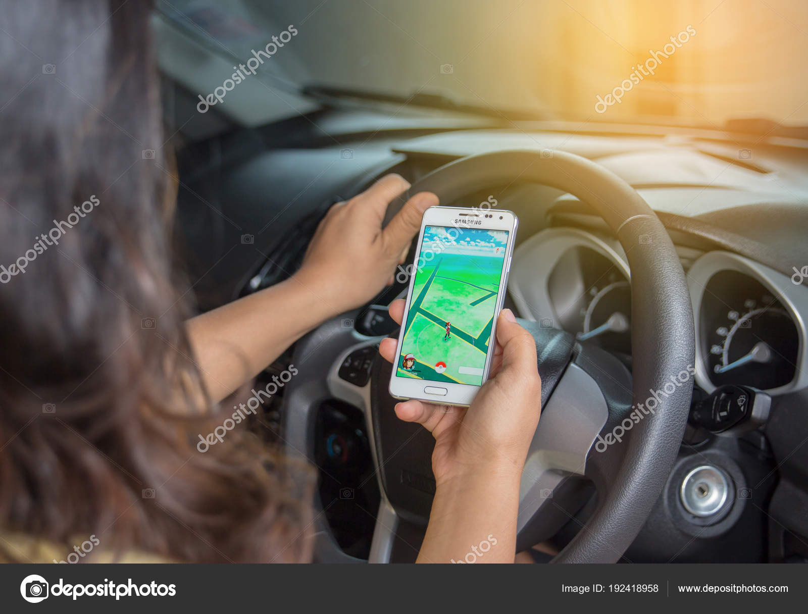 危険を示すを運転中 車の中ポケモン移動のゲーム携帯電話を保持している