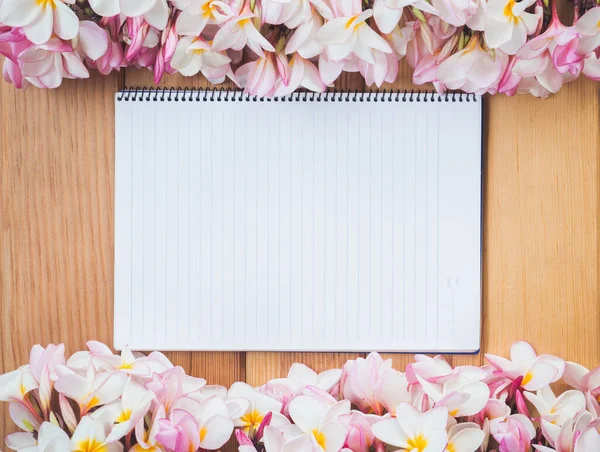 blank paper with flowers on a wooden background