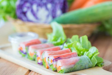 Taze salata sebzeleri, ahşap tabakta salata soslu makarna..