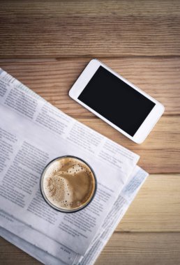 Gazete ve smartphone kafede kahve. 