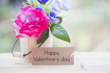 Mutlu sevgililer günü kartı yazarken masada gül vardı..