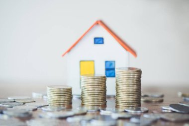 Ev modeli ve madeni para finans ve bankacılık konsepti için masaya.