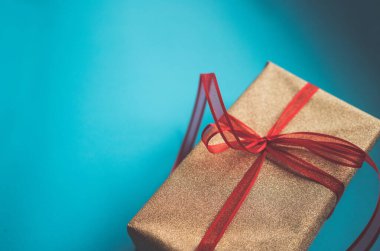 Mavi renkli kağıt arka planda altın hediye kutusu