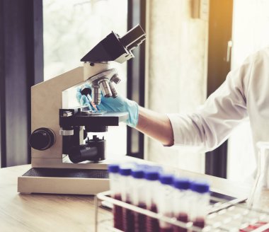 Laboratuvar araştırması için elinde test tüpleri tutan bir bilim adamı..