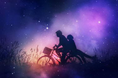 Sahada bisikletlerine aşık romantik bir çift gece gökyüzündeki yıldızları hayal ediyor..