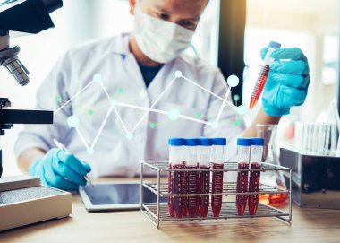 Laboratuvar araştırması için elinde test tüpleri tutan bir bilim adamı..