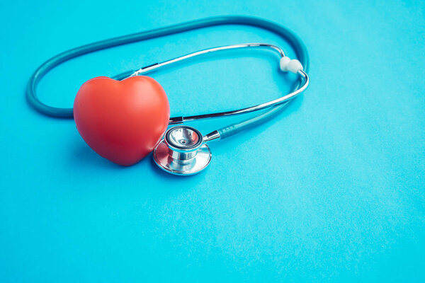 Red heart with stethoscope on blue background,Healthcare concept.