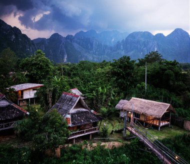 Bir dağ köyünün üstündeki fırtına bulutları, Vang Vieng, Laos.