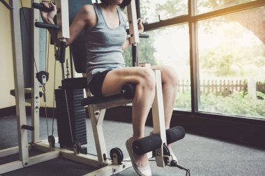 Genç kadın spor salonunda egzersiz yapıyor.