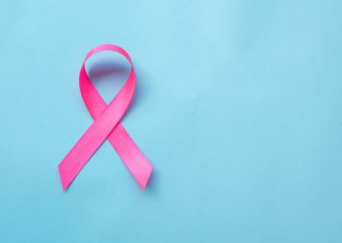 Mavi arka planda pembe kurdele, göğüs kanseri farkındalığı sembolü.