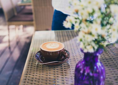 Kahve dükkanında kahve masasında bir fincan kapuçino.