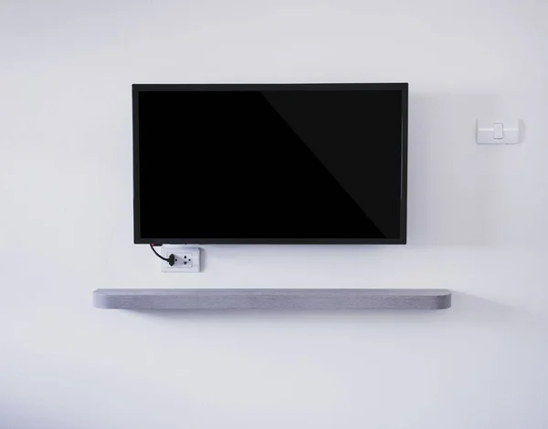 挂在白墙背景上的黑色电视机 — 图库照片