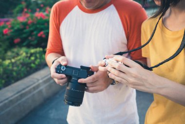 Kamera ekranlarına bakan turist çifti.