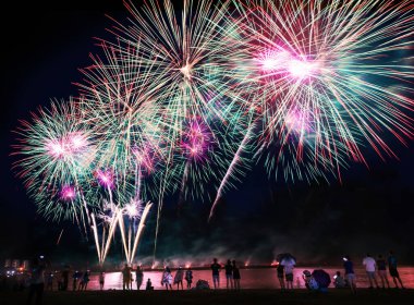 Kalabalık havai fişekleri izliyor ve sahilde kutlama yapıyor..