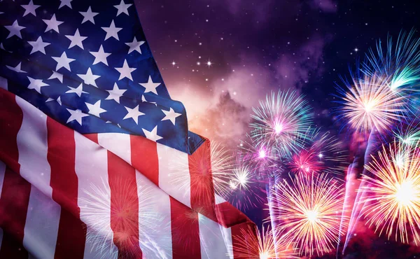 Amerikan bayrağı ve gece gökyüzü arkaplanlı havai fişekler. 