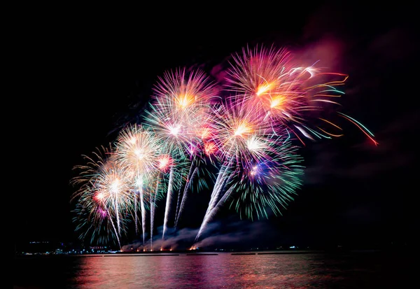 colorful fireworks on the black sky background over the sea.