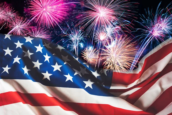 Amerikan bayrağı ve gece gökyüzü arkaplanlı havai fişekler. 